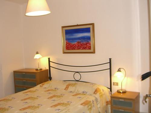 东塞斯特里La Piazzetta的一间卧室配有一张床、两个床头柜和两盏灯。
