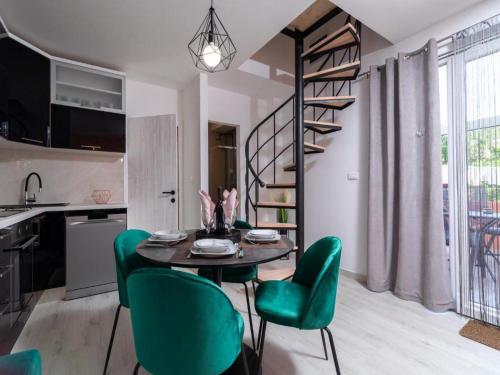 尼亚卢卡Apartment Dionis Domus的厨房以及带桌子和绿色椅子的用餐室。