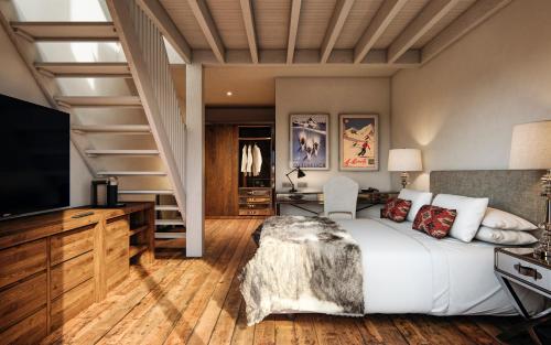 塞拉内华达Hotel Maribel的一间卧室设有床铺、电视和楼梯。