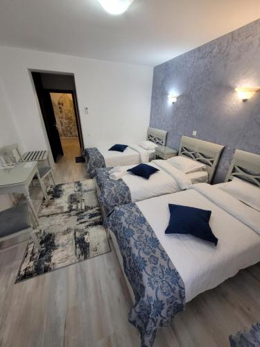 雅西Hotel Dorobanti的酒店客房设有三张床和一张桌子