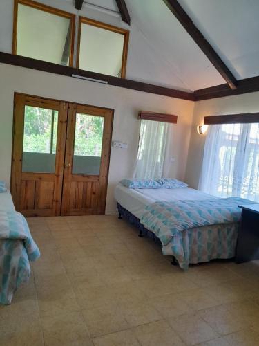 萨武萨武Fiji Fishing Holiday Bure的一间带两张床的卧室,位于带窗户的房间内