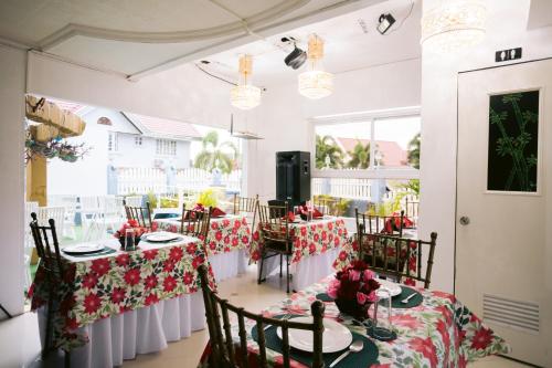 BalangaGrand Peninsula Suites的用餐室配有红色和白色桌布的桌子