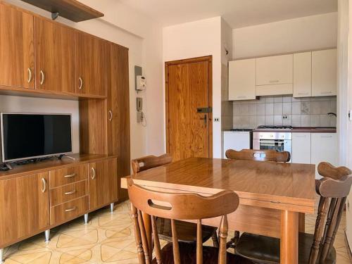 斯卡莱阿Brain Apartment Scalea - Parco Edil Blu的厨房配有木桌、椅子和电视