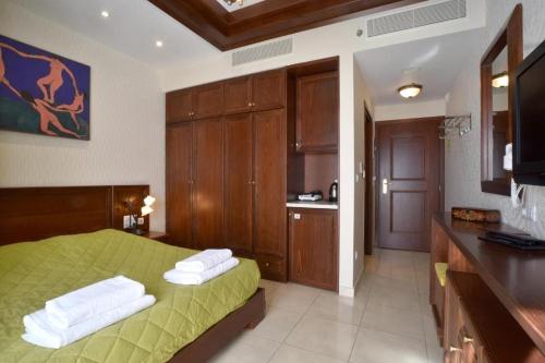 YerakárionAlexander Mountain Resort的一间带绿色床的卧室和一间厨房