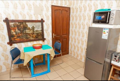 雅温得DUPLEXE HAUT STANDING centre ville Quartier Fouda的一间带桌子和冰箱的小厨房