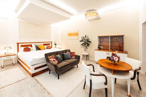 兹林贝赛中庭酒店的一间卧室配有一张床、一张桌子和一张沙发