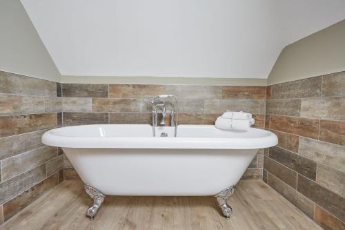 林肯Red Oak Barn, Ashlin Farm Barns的浴室设有白色浴缸,铺着瓷砖。