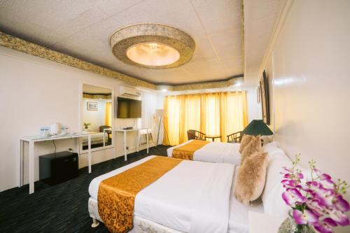 BalangaGrand Peninsula Suites的一间酒店客房,房间内设有两张床