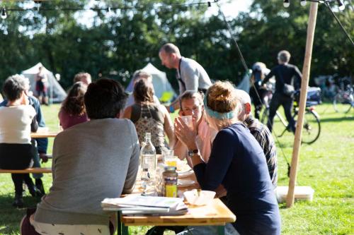 西泰尔斯海灵BlueCAMP Oerol24- Tent&Breakfast的一群坐在野餐桌上的人