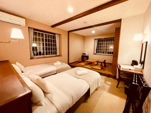 富士河口湖SAMURISE NORTH的酒店客房配有两张床和一张书桌