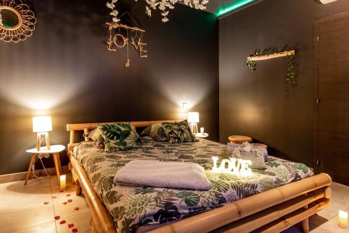 Le BreuilSweet Uni'vert Jacuzzi的一间卧室,床上有表示爱的标牌