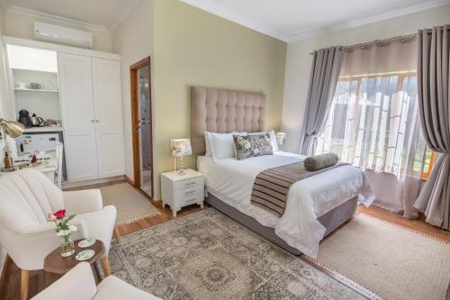 蒙塔古Mirihof Retreat and Olive Estate的卧室配有床、椅子和窗户。