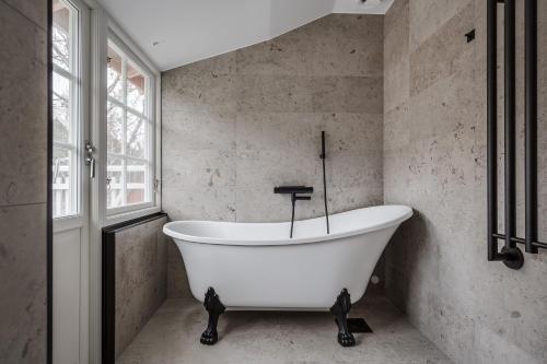 耶夫勒Trädgårdsmästarbostaden / The Gardeners Villa的带窗户的浴室内的白色浴缸