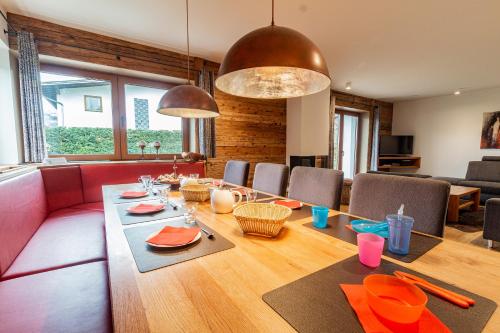 滨湖采尔Chalet Hohe Tauern - Steinbock Lodges的客厅配有红色的沙发和桌子