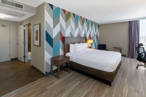 塔尔萨La Quinta Inn & Suites by Wyndham Tulsa Downtown - Route 66的酒店客房设有床和色彩缤纷的墙壁。