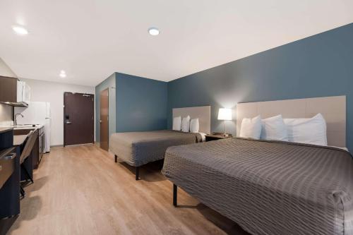凤凰城WoodSpring Suites Phoenix-Deer Valley的酒店客房带一张床和一个厨房