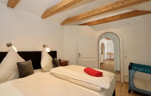 加尔米施-帕滕基兴Alpengold的卧室配有白色的床和红色枕头