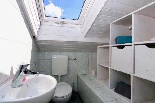 加尔米施-帕滕基兴Alpengold的一间带水槽、卫生间和天窗的浴室