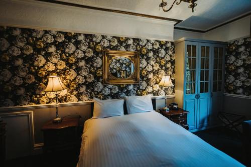切尔德桑顿Brook Hall Hotel的一间卧室配有一张大床,上面有两盏灯