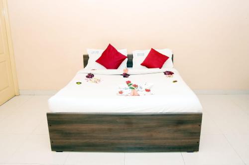 埃尔加德Grass dew的一张带白色床单和红色枕头的床