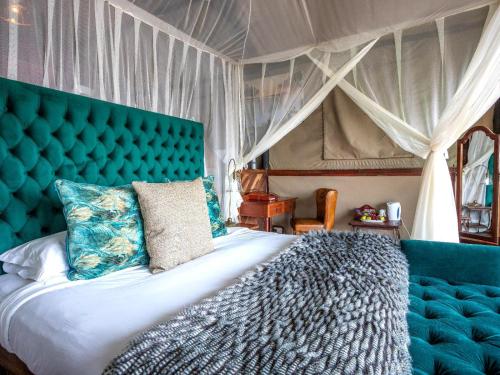 利文斯顿Tintswalo Siankaba的一间卧室配有一张大床和蓝色床头板
