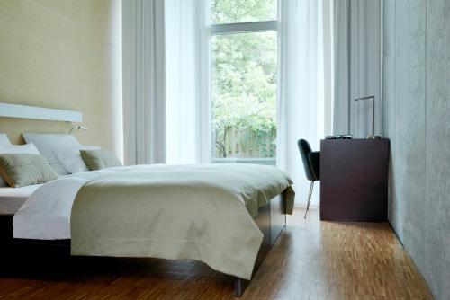 汉堡阿尔斯特维迪纳酒店的一间卧室设有一张大床和一个窗户。