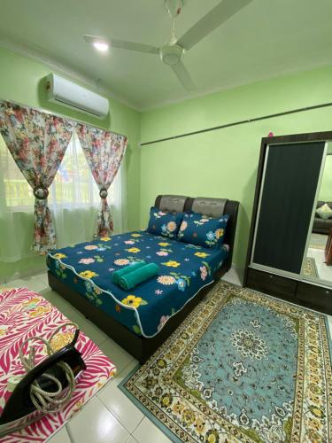 马日丹那Green Home Homestay Melaka的一间卧室配有一张床、镜子和地毯