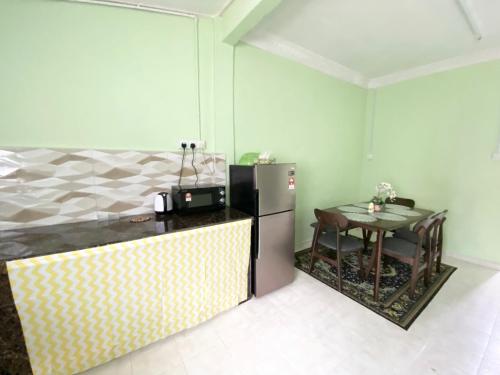 马日丹那Green Home Homestay Melaka的厨房配有冰箱和小桌子