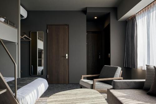 鹿儿岛FAV HOTEL KAGOSHIMACHUO的一间卧室配有一张床、一张沙发和一把椅子