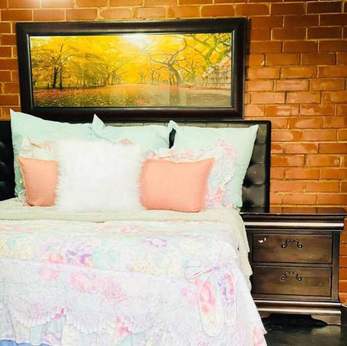 德班Ladybird的一张带粉红色枕头的床和上面的绘画