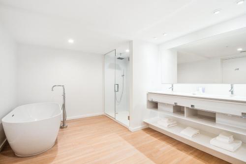 Bal HarbourBeach Haus Residences的白色的浴室设有浴缸和大镜子
