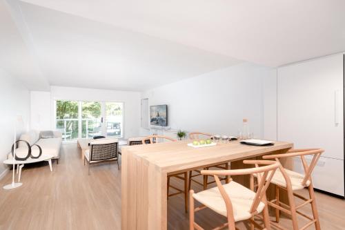Bal HarbourBeach Haus Residences的厨房以及带木桌和椅子的用餐室。