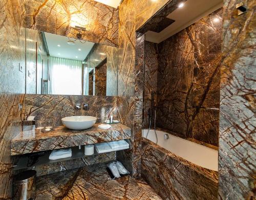 曼德洛德拉廖曼德洛别墅拉里奥度假村 的一间带水槽和大镜子的浴室