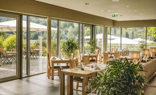 巴特尚道艾博瑞斯登兹温泉酒店的餐厅设有桌椅和窗户。