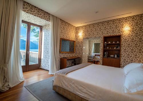 曼德洛德拉廖曼德洛别墅拉里奥度假村 的一间卧室设有一张大床和一个大窗户