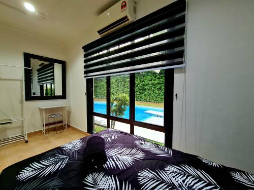 Kampong Alor GajahPrivate 4Bedroom Villa Pool,BBQ,Karaoke, Afamosa Resort的一间卧室设有大窗户,享有游泳池的景色