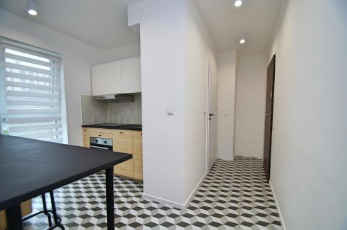 卡托维兹Apartament Bytkowska的厨房铺有黑白地板,配有黑桌。