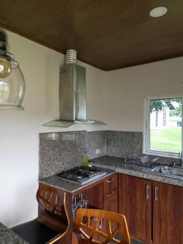下博克特Casita Boquete的厨房配有炉灶、水槽和窗户。