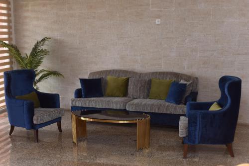 达喀尔拉斐尔特2号酒店的客厅配有沙发和2把蓝色椅子