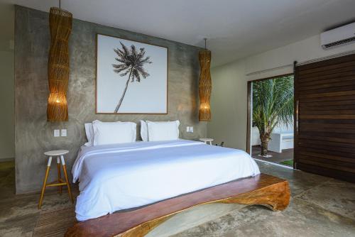 雅帕拉廷加Pe na Areia Boutique Hotel的卧室设有一张白色大床和一扇窗户。