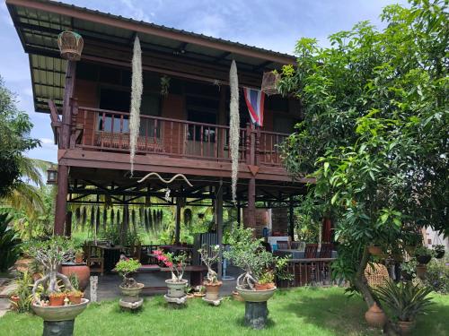 Ban Kho SaiMetha Country View Homestay Singburi的庭院内带盆栽阳台的房子