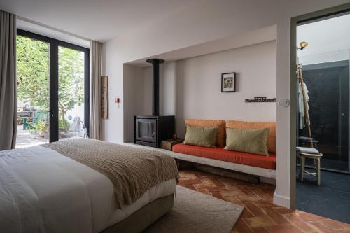 蓬塔德尔加达Solar de Santo André的一间卧室配有一张床和一张沙发