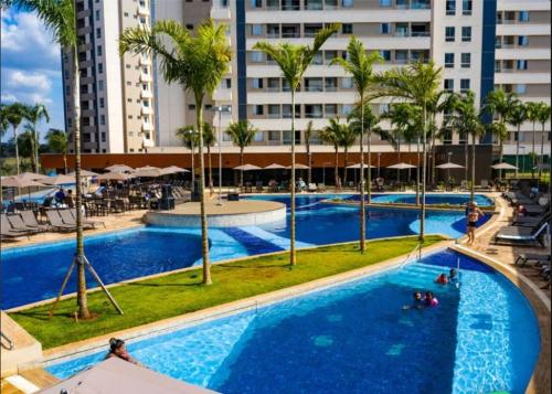 奥林匹亚Resort Solar das Águas的享有棕榈树和建筑的游泳池的顶部景致