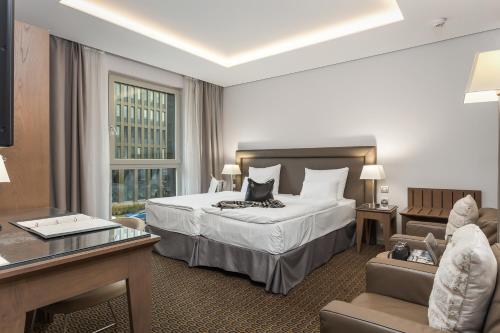 布拉格布拉格皇家酒店的大型酒店客房,配有一张床和一张书桌