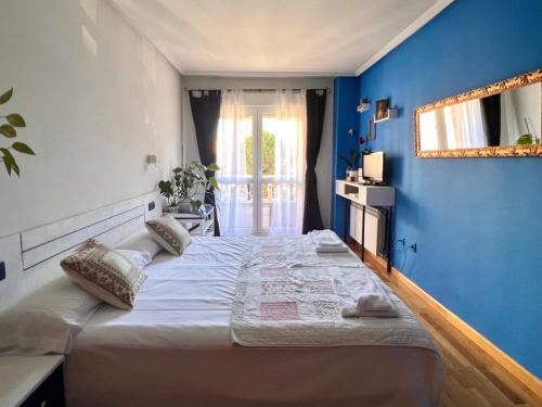 莱昂Housingleon- Casa Oliva con Garaje的一间卧室设有一张蓝色墙壁的大床