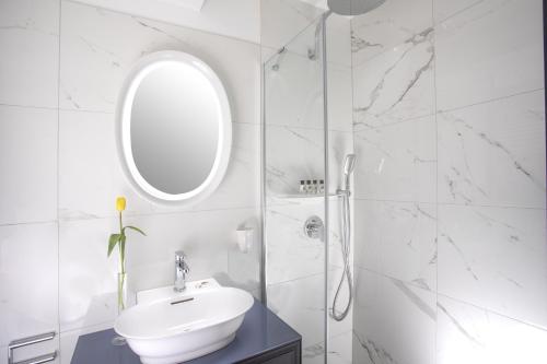 维也纳ARTIST Boutique Hotel的白色的浴室设有水槽和镜子