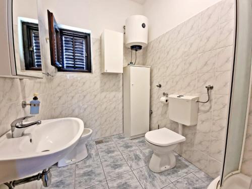 奥库格哥恩基Apartman Irena with terase end private parking的白色的浴室设有水槽和卫生间。