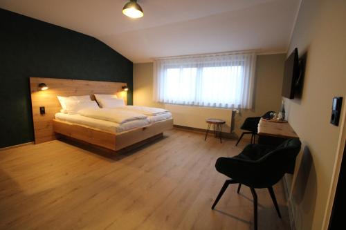 蒙绍DER Hirsch Hotel的一间卧室配有一张床、一张桌子和一把椅子