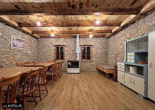 默主歌耶La Pietra Family Hotel的用餐室设有木桌和石墙