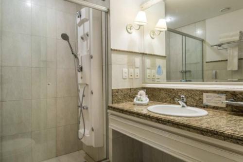 弗洛里亚诺波利斯IL Campanario - Suíte的浴室配有盥洗盆和带镜子的淋浴